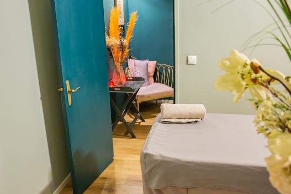 Behandelkamer met een petrolblauwe deur en droogbloemen.