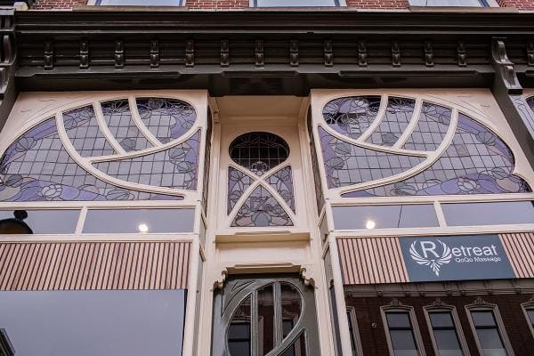 De bovenbouw van de gevel met gebogen glas-in-loodramen.