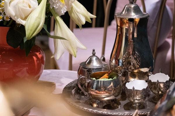 Een zilveren theeservies met bloemen in de salon.